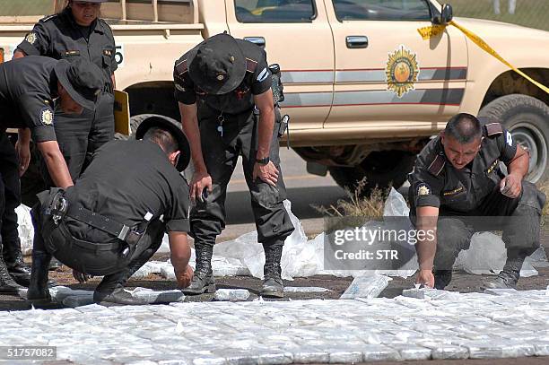 Agentes de la seccion antidrogas de la Policia Nacional Civil observan paquetes que contienen cerca de 450 kgs de cocaina antes de ser destruida, en...