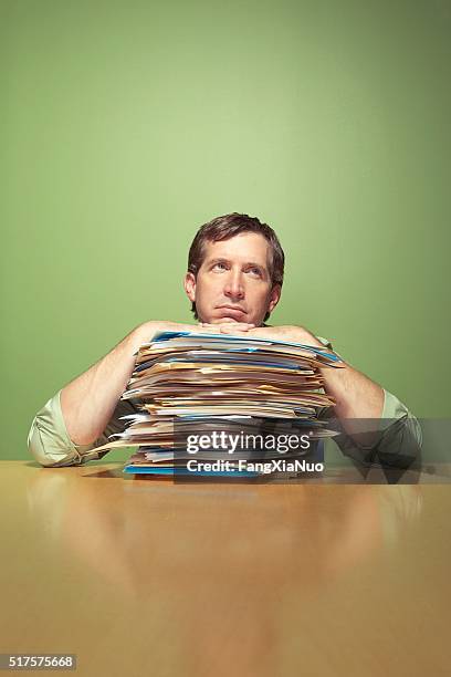 man with piles of work - newspaper stack stock pictures, royalty-free photos & images