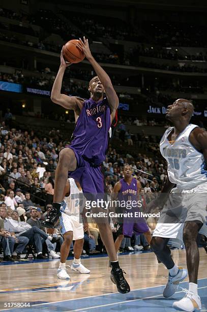 Loren Woods of the Toronto Raptors goes to the basket against Francisco Elson of the Denver Nuggets on November 17, 2004 at Pepsi Center in Denver,...