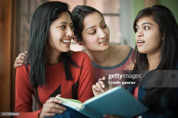 late teen happy girl students studying a book together. - indian college girl stock pictures, royalty-free photos & images