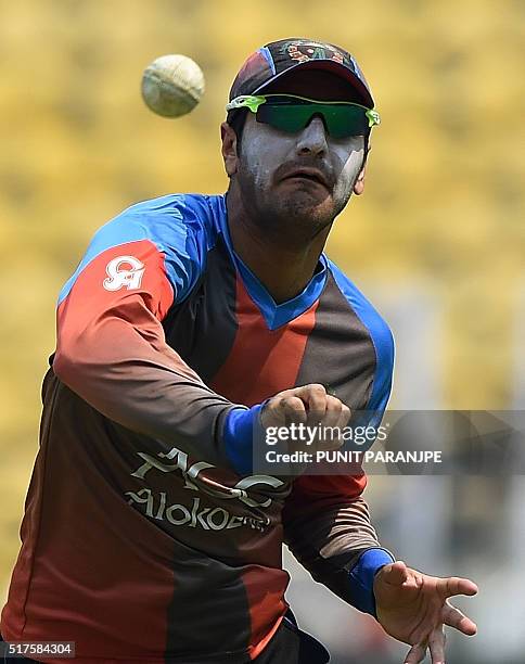Afghanistan's Usman Ghani throws a ball as he takes part in a training session at The Vidarbha Cricket Association Stadium in Nagpur on March 26,...