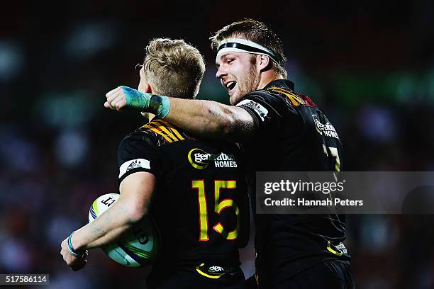 Damian McKenzie of the Chiefs celebrates with Sam Cane of the Chiefs after scoring a try during the round five Super Rugby match between the Chiefs...