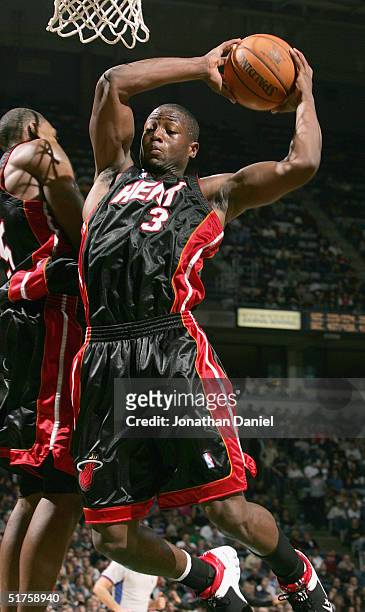 Guard Dwyane Wade of the Miami Heat pulls down a rebound during a game against the Milwaukee Bucks on November 17, 2004 at Bradley Center in...