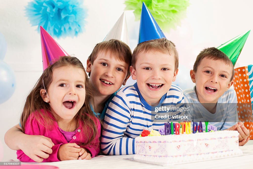 Four happy children celebrating a birthday