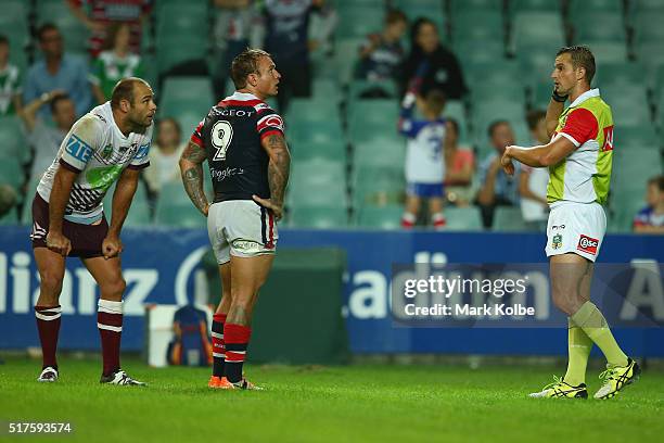 Brett Stewart of the Eagles and Jake Friend of the Roosters watch replays on the big screen as referee Nick Beashel waits for a video referee...