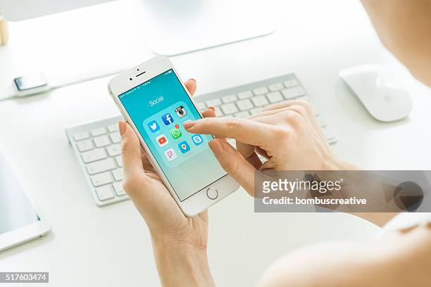 social media apps on apple iphone 6s - holding iphone stockfoto's en -beelden