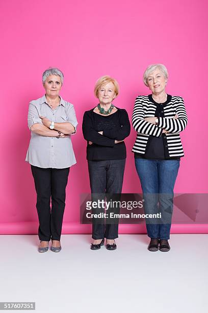 group of mature friends smiling in pink studio - 3 old people stock-fotos und bilder