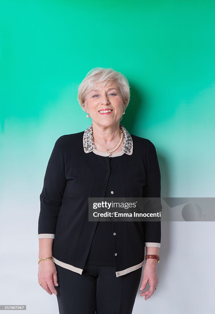 Mature woman against green background smiling
