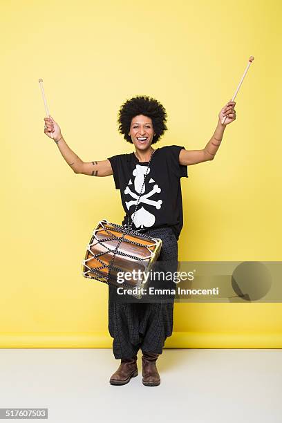 happy young woman playing african drum - instrument à percussion photos et images de collection