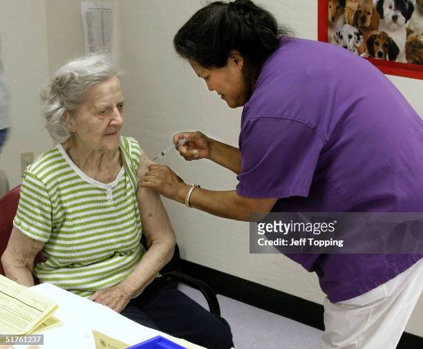 Alice Budak of Goodyear, Arizona receives a flu shot from Pearl Napa, LPN at one of Maricopa county's immunization clinics for high risk individuals...