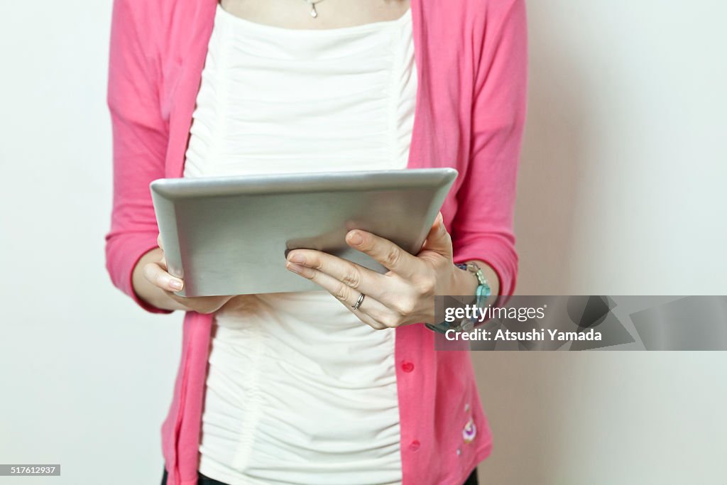 Japanese woman using digital tablet,mid section