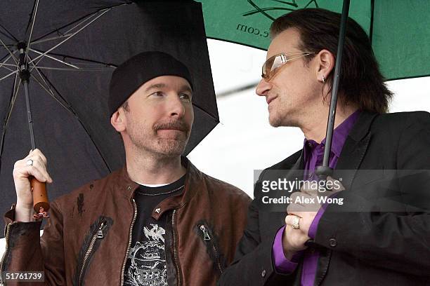 Lead singer Bono and The Edge wait for their turn to perform during the official opening ceremony of the Clinton Presidential Library November 18,...