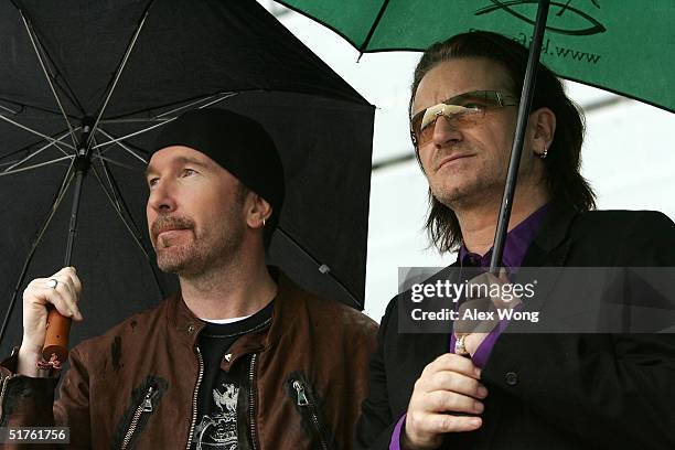 Lead singer Bono and The Edge wait for their turn to perform during the official opening ceremony of the Clinton Presidential Library November 18,...