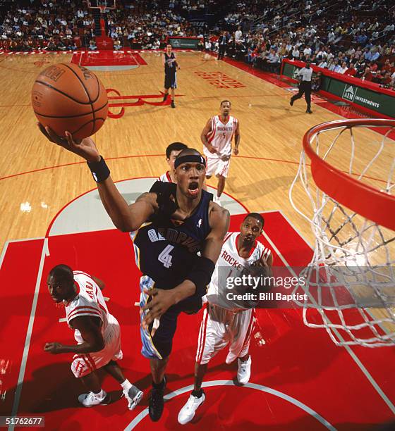 Stromile Swift of the Memphis Grizzlies makes a layup against Tracy McGrady and Charlie Ward of the Houston Rockets at Toyota Center on November 9,...