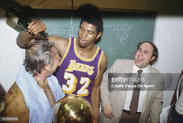 Magic Johnson of the Los Angeles Lakers pours a bottle of champagne over the owner of the Lakers Jerry Buss after winning Game 6 of the 1980 finals...