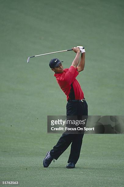 Tiger Woods watches the flight of his ball during the Masters Tournament at the Augusta National Golf Club on April 13, 1997 in Augusta, Georgia....