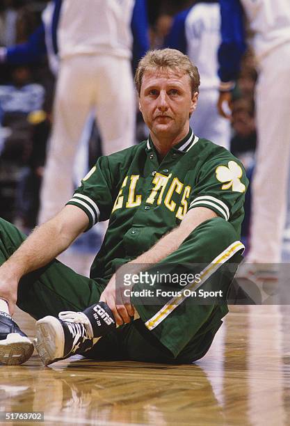 Larry Bird of the Boston Celtics sits and stretches on the sidelines during the 1989 season .