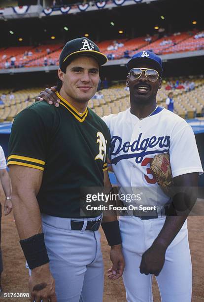 Ex teammates Jose Canseco of the Oakland Athletics and Mike Davis of the Los Angeles Dodgers pause for a photo during the World series at Dodger...