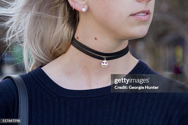 Emily Mercer wearing Rag & Bone navy sweater, Alison Lou choker necklace with heart eyes emoji pendant and PaPer minT black leather bag on March 26,...