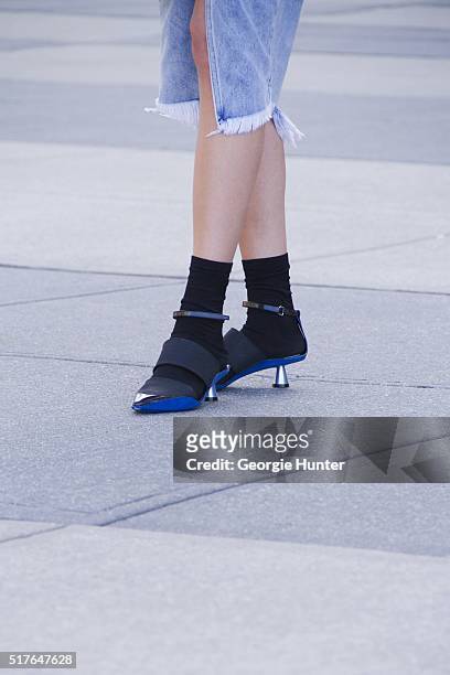Emily Mercer wearing ripped One Teaspoon denim skirt, black and blue Kenzo shoes and black socks by Stance on March 26, 2016 in New York City.