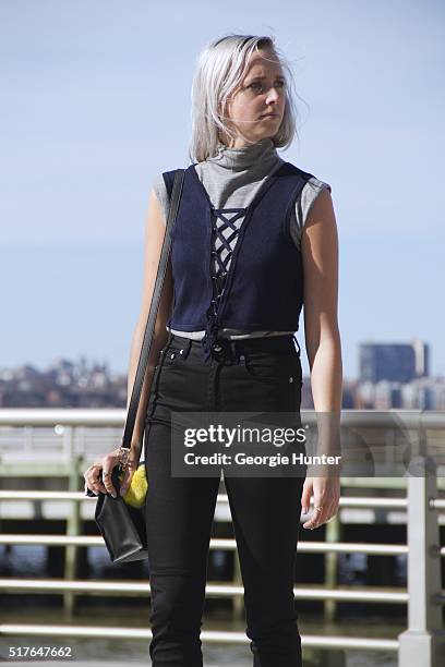 Emily Mercer wearing vintage grey turtleneck sleeveless sweater, blue Urban Outfitters navy top with tie, black high waisted BLK DNM pants, left hand...