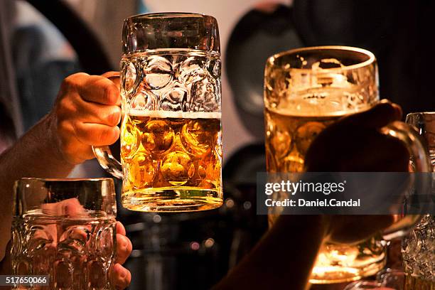 people raising beer mugs for toast - theresienwiese stock-fotos und bilder