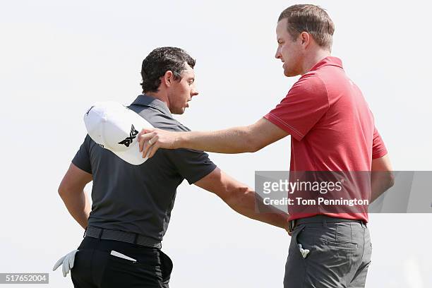 Rory McIlroy of Northern Ireland shakes hands with Chris Kirk of the United States after McIlroy won their match 4&3 on the 15th green during the...