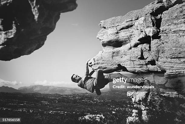 blanco y negro foto de freeclimber colgante en roca - black rock climber fotografías e imágenes de stock