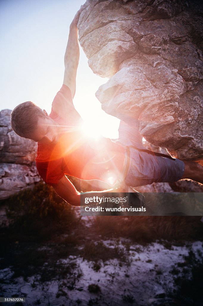 Homem escalada de giz com mão saco pendurado rocha