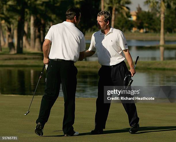 Luke Donald and Paul Casey of England shake hands after their foursomes match during the second round of the World Golf Championships World Cup, held...