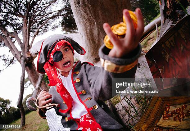 dressing up pirate child finding gold coins in treasure chest - golden boy stock pictures, royalty-free photos & images