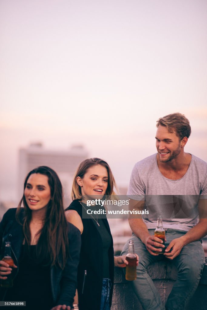 Happy young adult friends enjoying a rooftop party