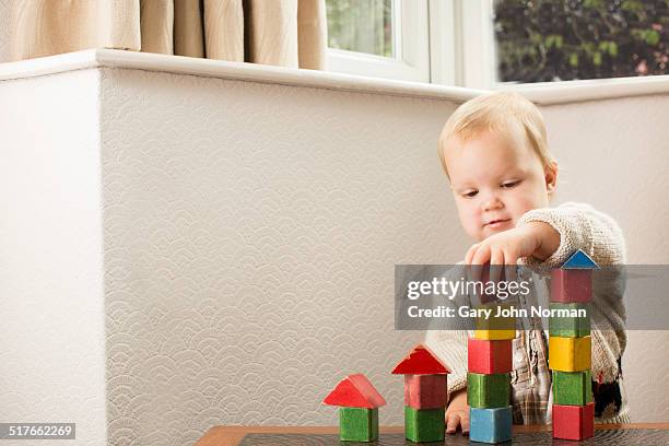 girl 18 months building towers with wooden bricks - baby blocks stock pictures, royalty-free photos & images