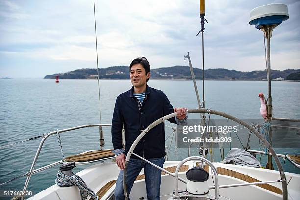 mature man driving a lusury yacht - steering boat stock pictures, royalty-free photos & images