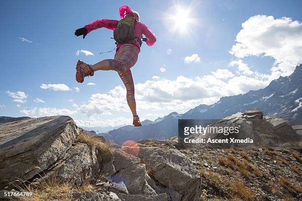 low view of trail runner traversing mtn ridge - leap forward stock pictures, royalty-free photos & images