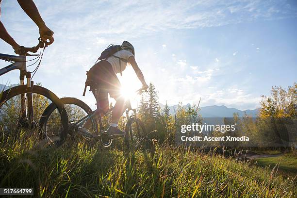 mountain bikers descend mtn ridge crest, autumn - mountainbiken fietsen stockfoto's en -beelden