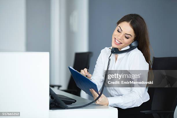 young happy secretary talking on the phone. - secretary stock pictures, royalty-free photos & images