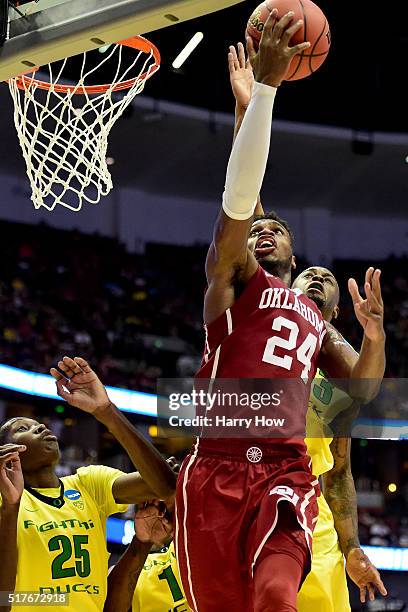 Buddy Hield of the Oklahoma Sooners shoots Elgin Cook of the Oregon Ducks in the second half in the NCAA Men's Basketball Tournament West Regional...