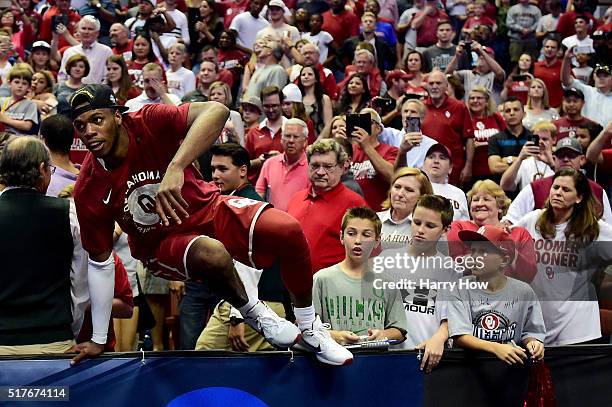 Buddy Hield of the Oklahoma Sooners climbs back onto the court after celebrating with fans after the Sooners 80-68 victory against the Oregon Ducks...