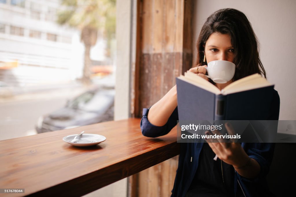 女の子 飲むコーヒーや読書でのカフェ