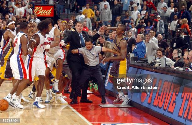 Ben Wallace of the Detroit Pistons and teammates are kept apart from Ron Artest of the Indiana Pacers by Pacers head coach Rick Carlisle and official...