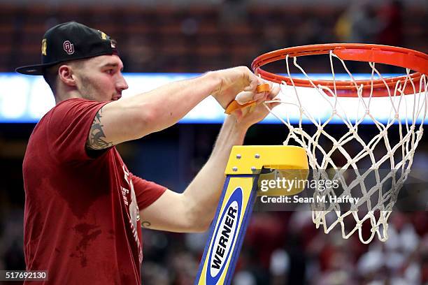 Ryan Spangler of the Oklahoma Sooners cuts down a piece of the net after the Sooners 80-68 victory against the Oregon Ducks in the NCAA Men's...
