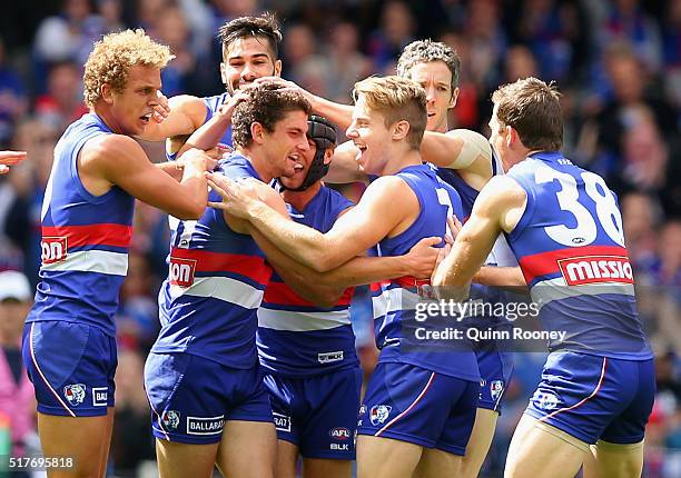 Tom Liberatore of the Bulldogs is congratulated by team mates after kicking a goal during the round one AFL match between the Western Bulldogs and...