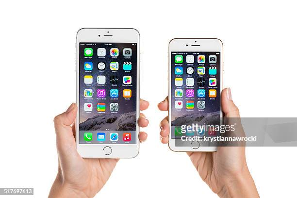 comparing iphone 6 and iphone 6 plus - holding iphone stockfoto's en -beelden