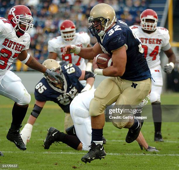 Naval Academy Midshipman 1st Class Kyle Eckel breaks through a line of Rutgers University Scarlet Knights defenders enroute to a touchdown in the 1st...