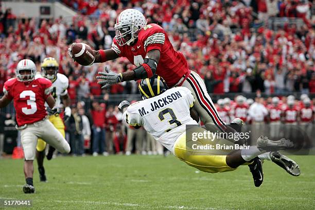 Wide receiver Santonio Holmes of the Ohio State Buckeyes dives into the end zone for a touchdown over cornerback Marlin Jackson of the Michigan...