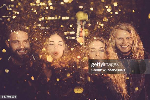 teen friends enjoying night party with golden confetti - couple au lit stockfoto's en -beelden
