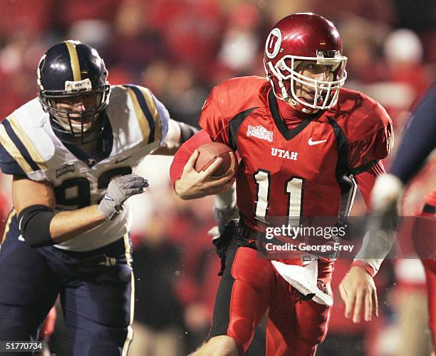 Quarterback Alex Smith of the University of Utah scrambles for a first down as John Denney of BYU gives chase during the second quarter November 20,...