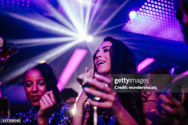 happy young women drinking cocktail in night club party - girl swing stockfoto's en -beelden