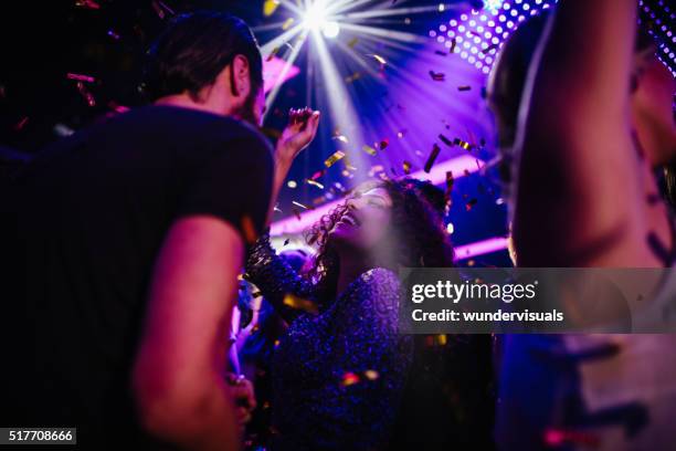 jeunes amis s'amuser avec des confettis de la fête au club - rave party photos et images de collection